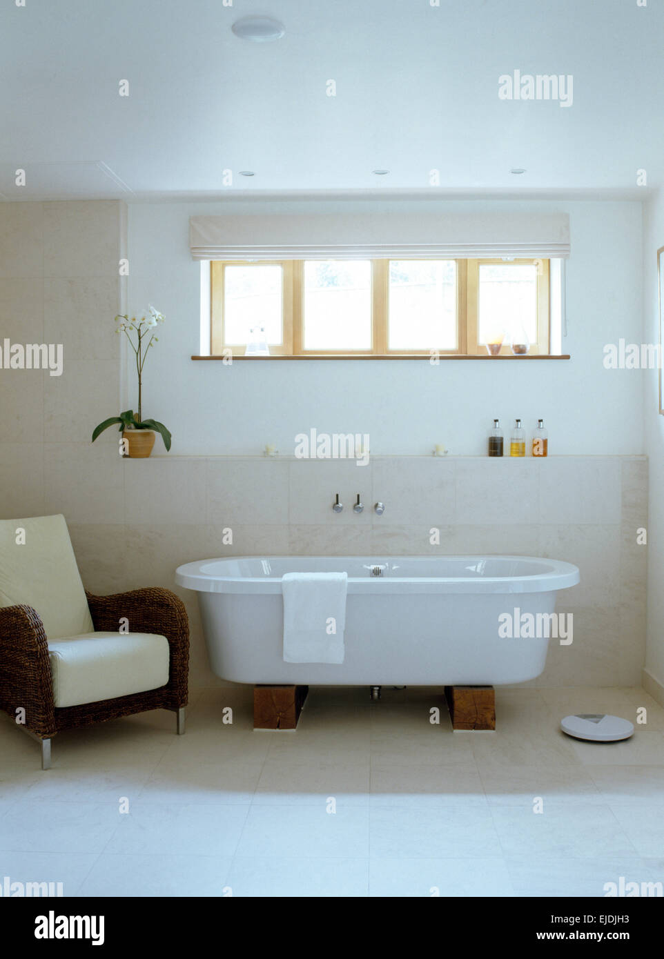 Rotolo di moderno bagno superiore in bianco bagno moderno con poltrone in vimini Foto Stock