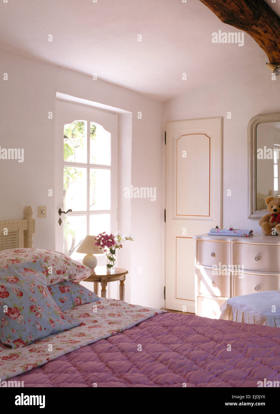 Rose modellato cuscini e piumini rosa sul letto nel paese francese camera da letto Foto Stock