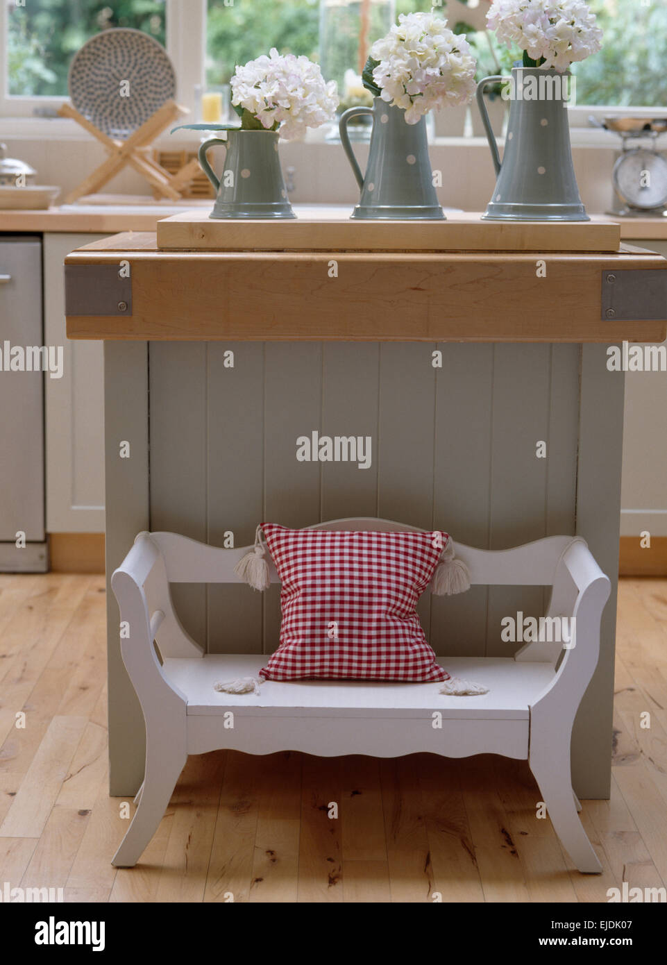 Bambino in legno dipinto di assestarsi contro unità di isola in cucina di paese Foto Stock Bambino in legno dipinto di assestarsi contro unità di isola in cucina di paese Foto Stock