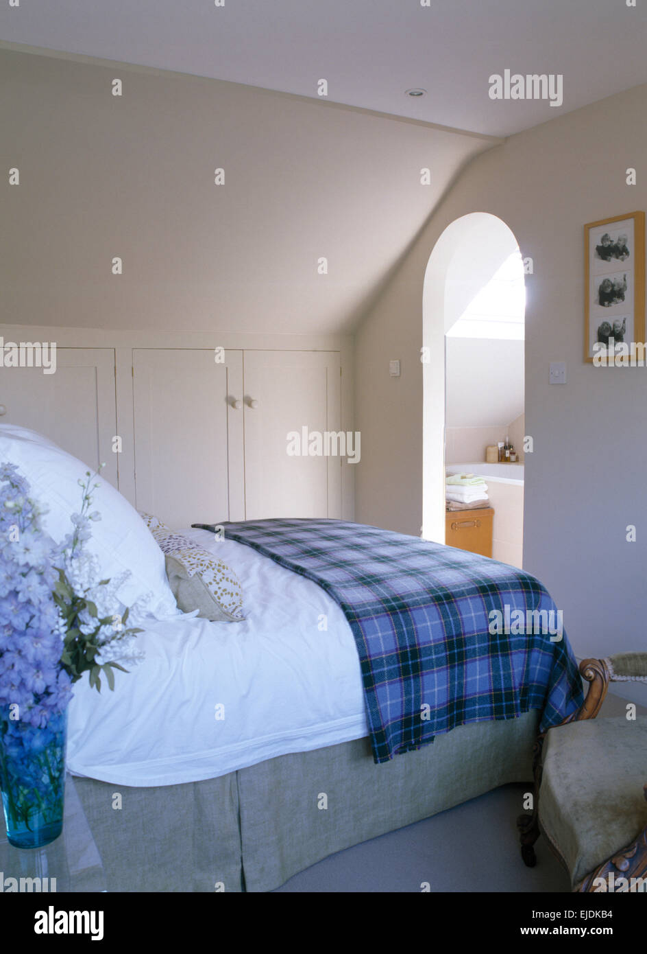 Blu ripiegata plaid coperta sul letto in mansarda camera da letto con porta di ingresso alla stanza da bagno en-suite Foto Stock