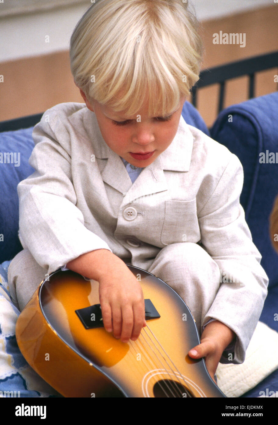 Close-up di piccoli capelli biondo ragazzo con un bambino la chitarra Foto Stock