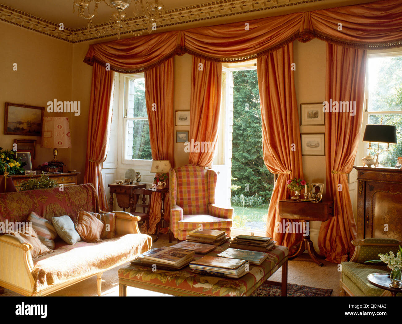 Opulenti swagged peach tende di seta su porte e finestre di degli anni novanta la stanza di seduta Foto Stock