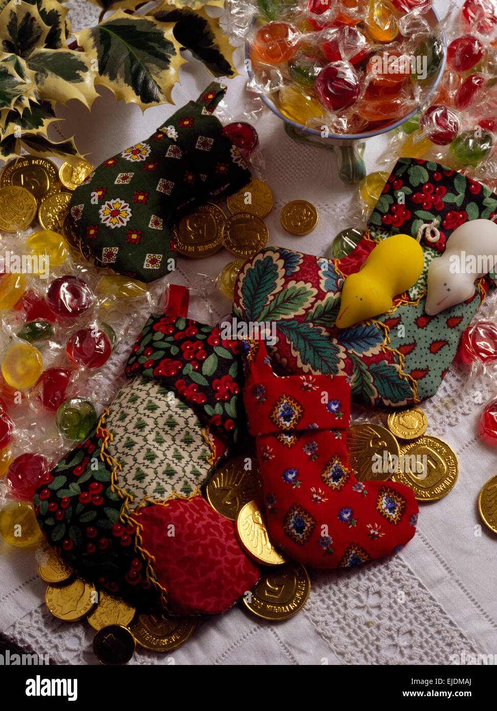 Close-up di miniatura calze di Natale con i sacchetti di caramelle e oro ricoperto di monete di cioccolato Foto Stock
