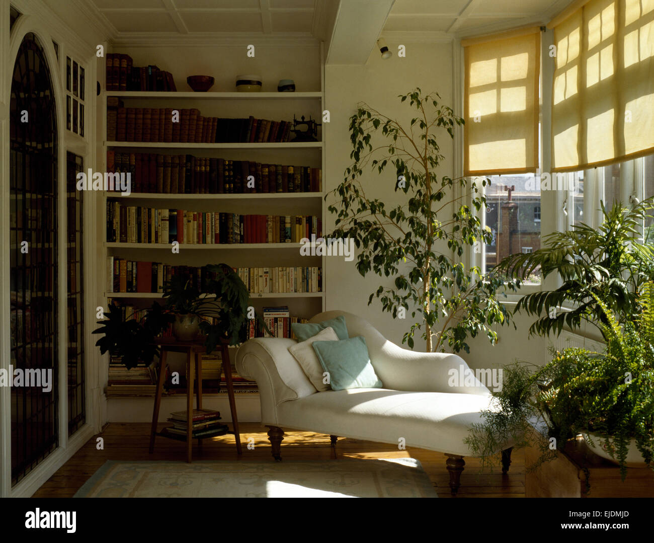Houseplants e white chaise longue in ottanta soggiorno Foto Stock