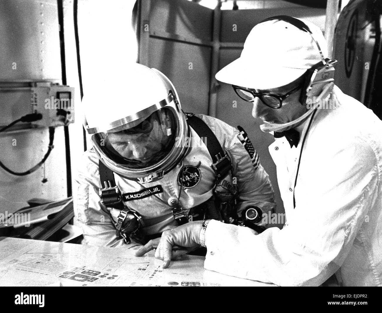 Guenter Wendt e Wally Schirra, l'astronauta Walter M. Schirra, Jr. Confessa con Guenter F. Wendt, direttore del test delle navicelle McDonnell, durante l'attività simulata di test di volo nella White Room in cima al Launch Pad 19. Foto Stock
