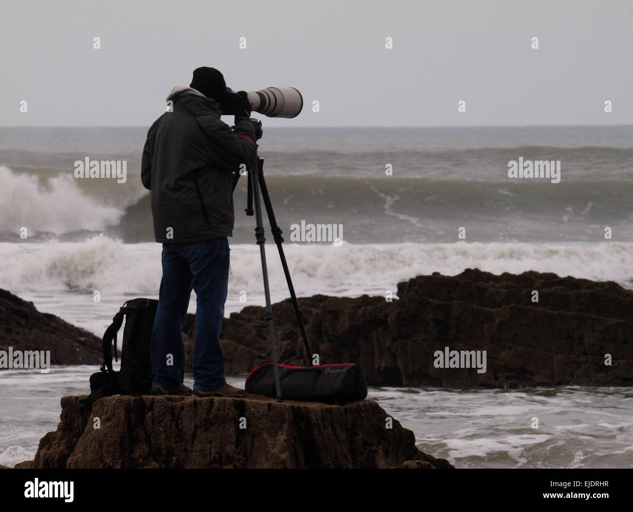Fotografo sportivo con lenti molto grandi di fotografare i surfisti, Bude, Cornwall, Regno Unito Foto Stock