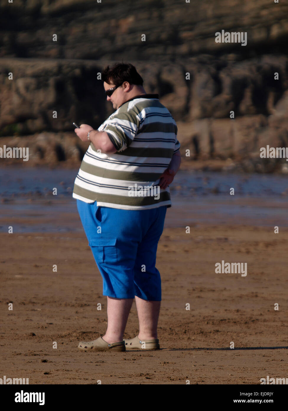 Uomo obesi in spiaggia, Bude, Cornwall, Regno Unito Foto Stock