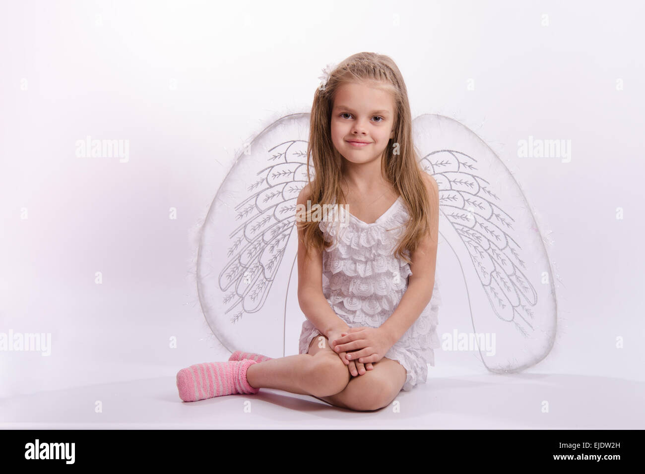 6 anno vecchia ragazza in un bright angel costume con ali su sfondo bianco Foto Stock