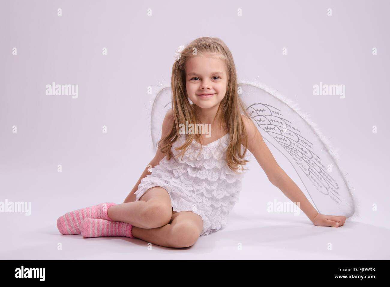 6 anno vecchia ragazza in un bright angel costume con ali su sfondo bianco Foto Stock