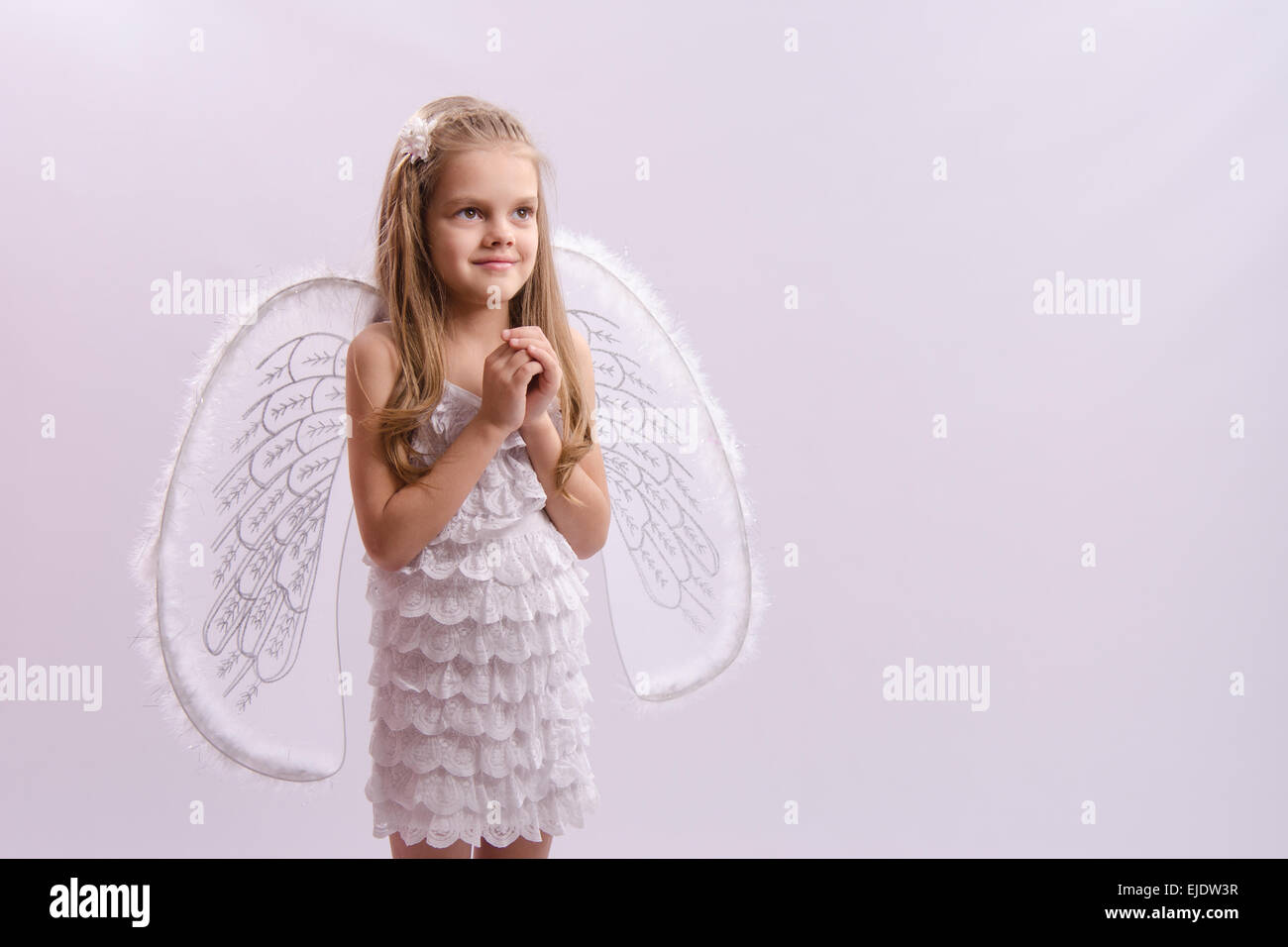 6 anno vecchia ragazza in un bright angel costume con ali su sfondo bianco Foto Stock