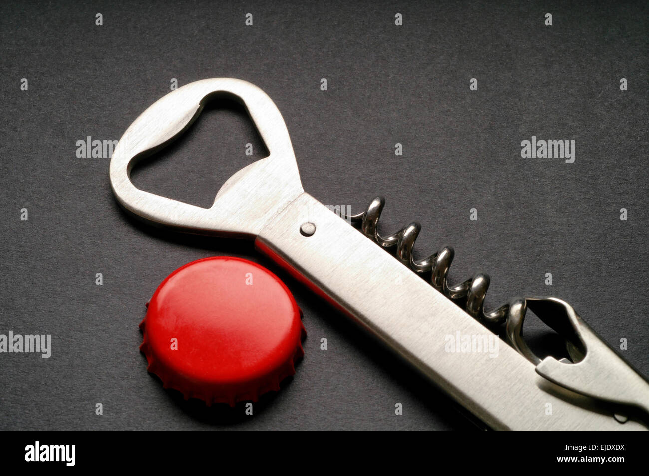 Cavatappi in acciaio e apribottiglie rosso con tappo a corona Foto Stock
