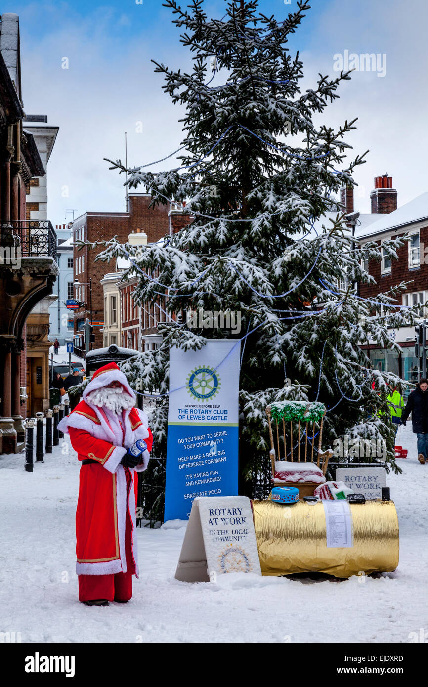 Un membro di Lewes Rotary Club raccoglie fondi per beneficenza vestiti da Babbo Natale, Lewes, Sussex, Regno Unito Foto Stock