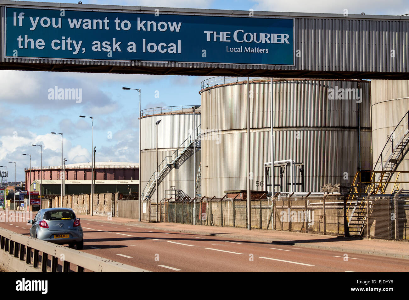 Il corriere banner pubblicitario su un ponte pedonale che conduce al petrolio grandi serbatoi di stoccaggio a Dundee, Regno Unito Foto Stock