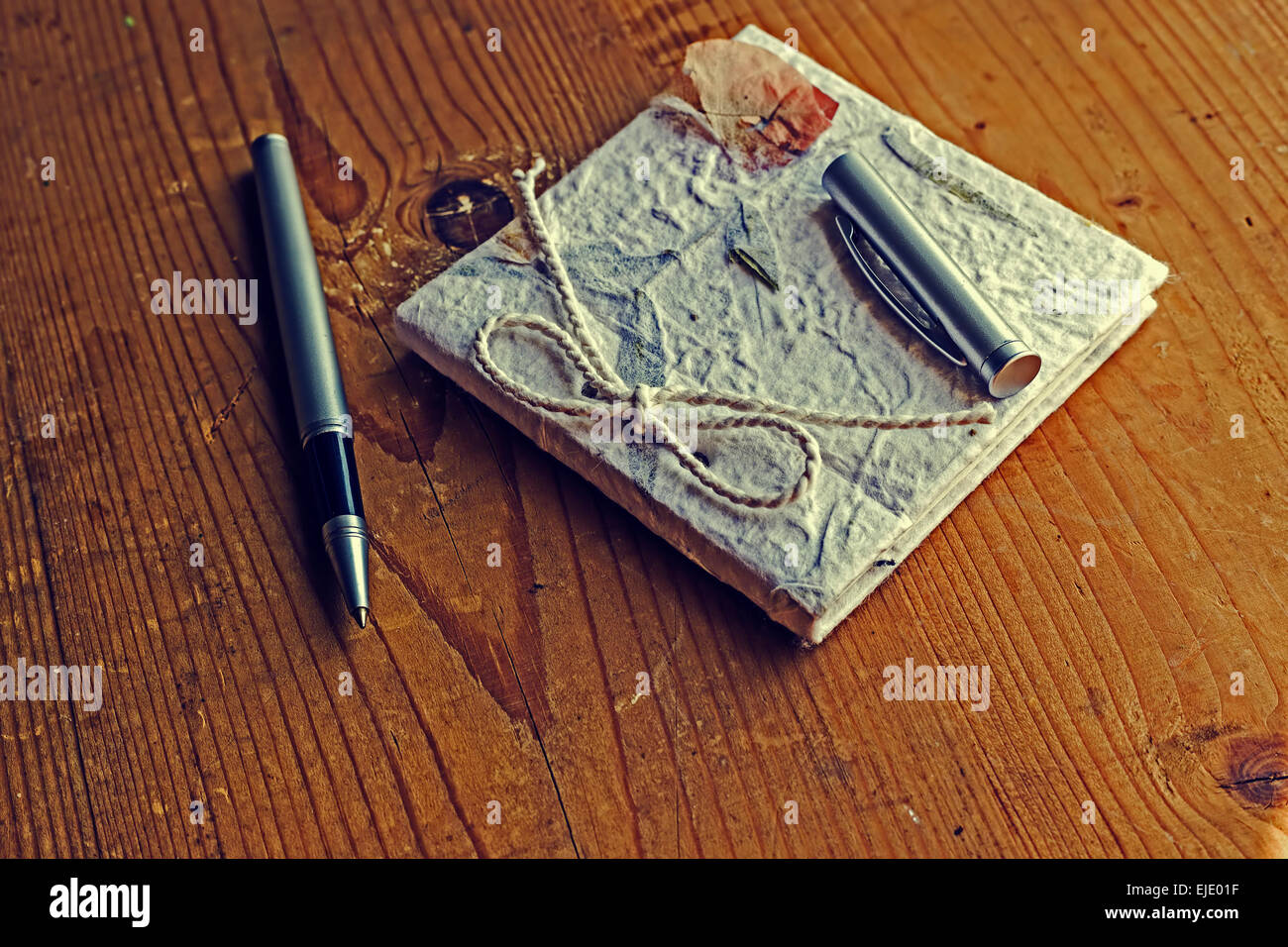 Diario di vecchi ricordi con una penna su un tavolo di legno. Elaborazione vintage. Foto Stock