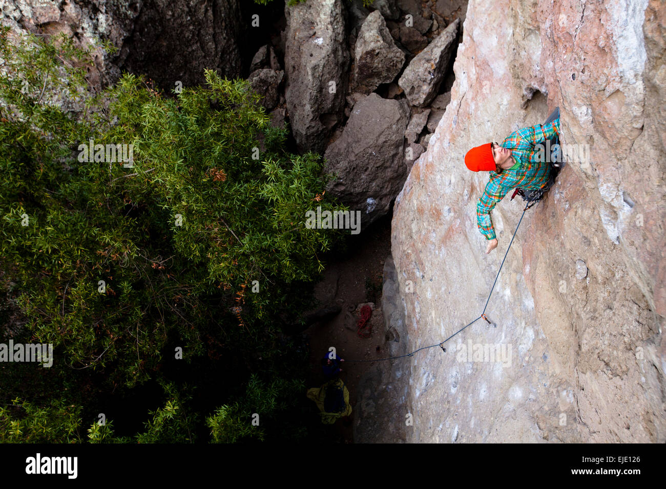 Un scalatore maschio in un arancione beanie e multicolori shirt salite gioiello di famiglia (5.10d) sul Monte meravigliosa in Malibu Canyon membro Foto Stock