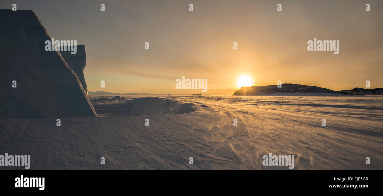 Tramonto dietro un iceberg guardando a Nord attraverso la superficie ghiacciata del Mare di Ross, Antartide. Foto Stock