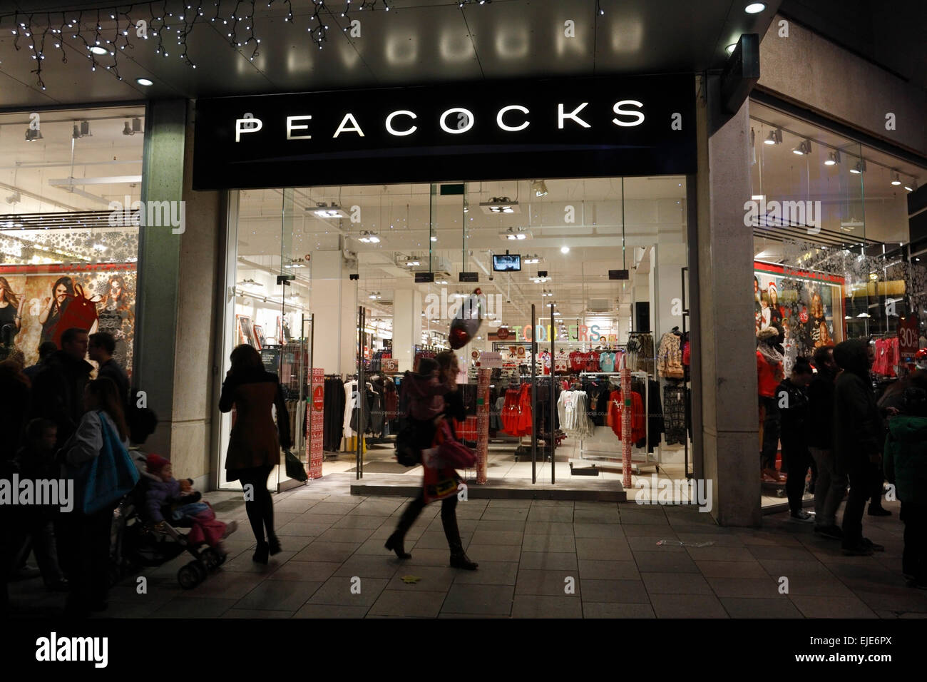Shopping natalizio in tarda serata al negozio di panni di pavoni a Cardiff Centro città Galles Regno Unito Foto Stock