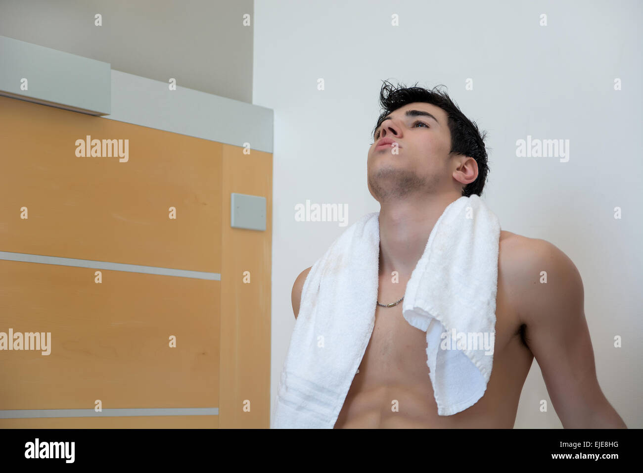 Ritratto di bel giovane uomo Shirtless coperti con un asciugamano a casa nella sua camera da letto Foto Stock