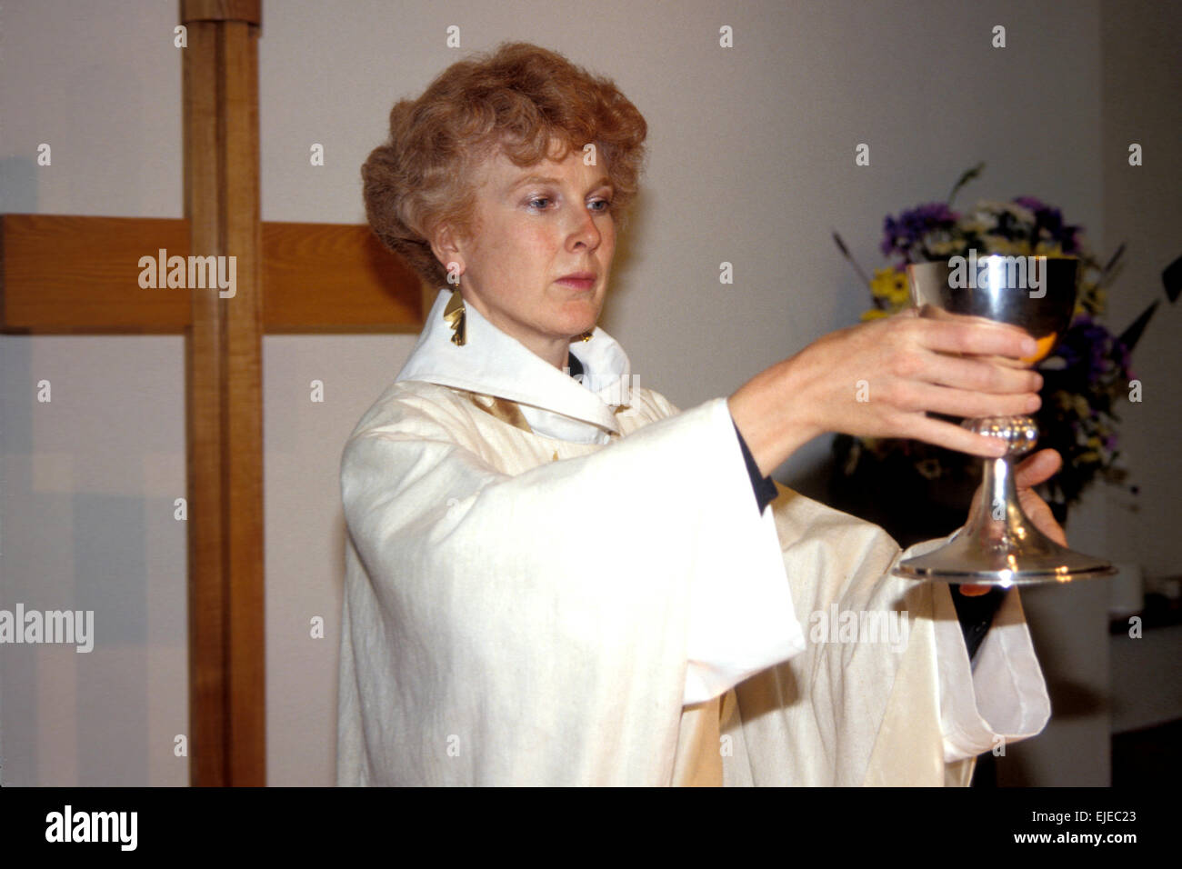 Katherine Rumens, donna sacerdote in Inghilterra, tenendo il calice durante la santa Eucaristia Foto Stock