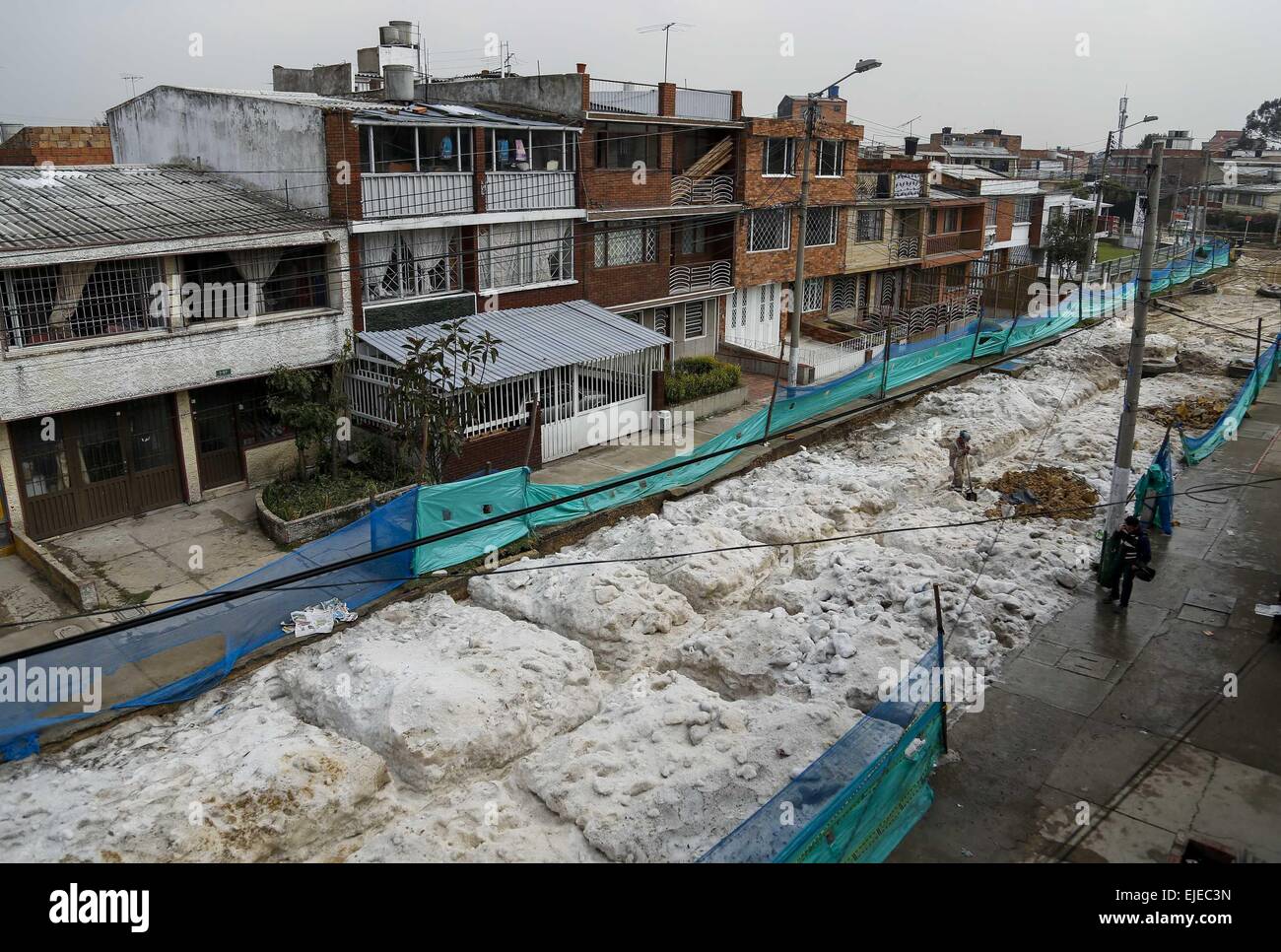 Bogotà, Colombia. 24 Mar, 2015. Un impiegato comunale pulisce una strada nella città di Bogotà, Colombia, il 24 marzo 2015. Secondo la stampa locale in diversi settori del capitale colombiana città sono state colpite da forti piogge accompagnate da grandine il Marzo 22, causando danni a centinaia di case e di generazione di inondazioni. Credito: Mauricio Alvarado/COLPRENSA/Xinhua/Alamy Live News Foto Stock