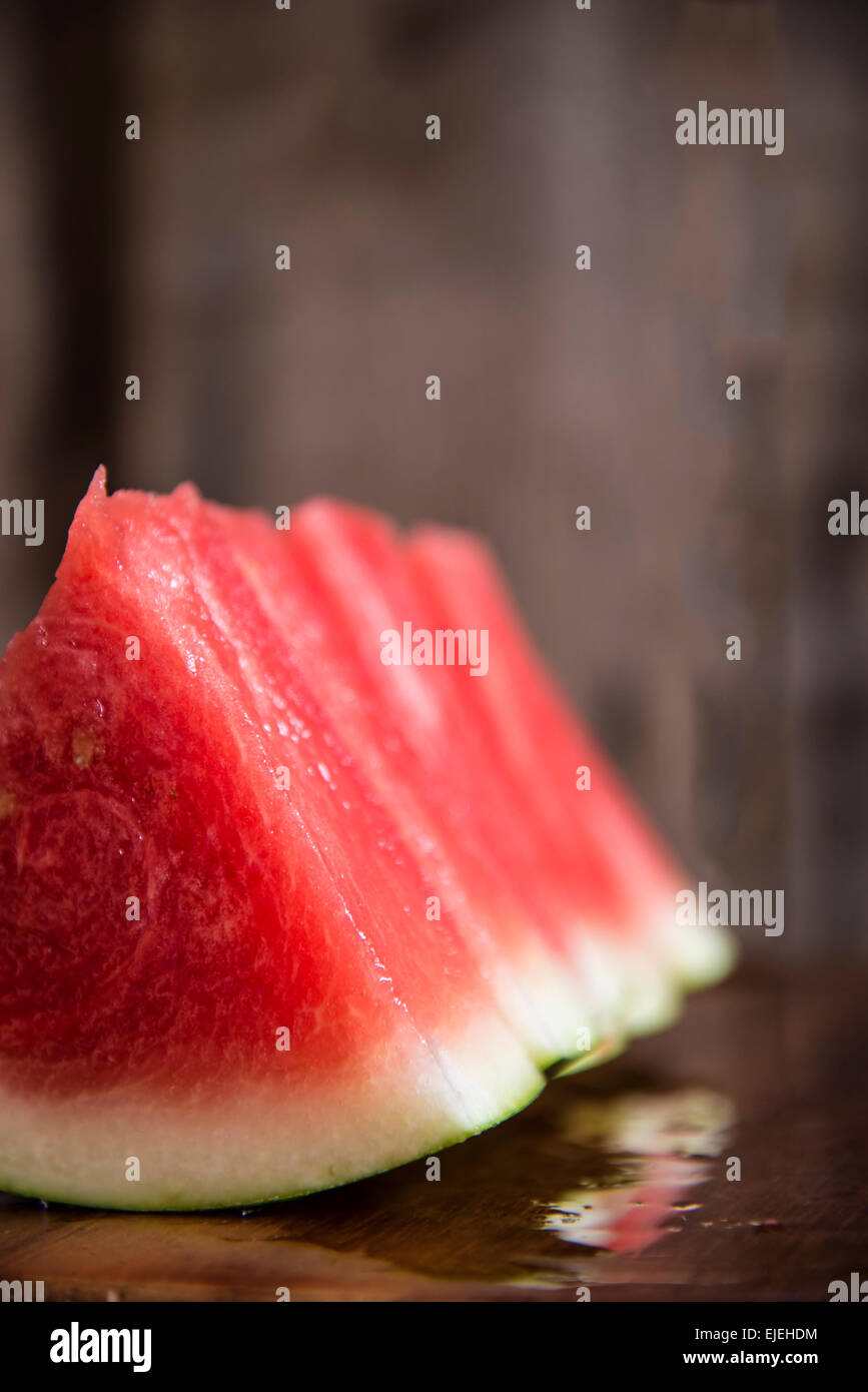 Fette di anguria succosa sul tagliere di legno in cucina Foto Stock