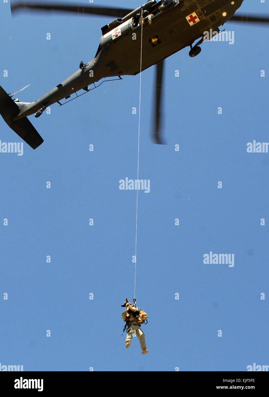 Il personale Sgt. Michael entre con "Rronnie", suoi militari cane da lavoro, 554th Polizia Militare azienda viene issato in un UH-60 Blackhawk elicottero durante un canino-paranco di formazione missionaria Luglio 15 vicino Bagram Airfield, Afghanistan. US Army foto di Spc. Aubree Rundle Foto Stock