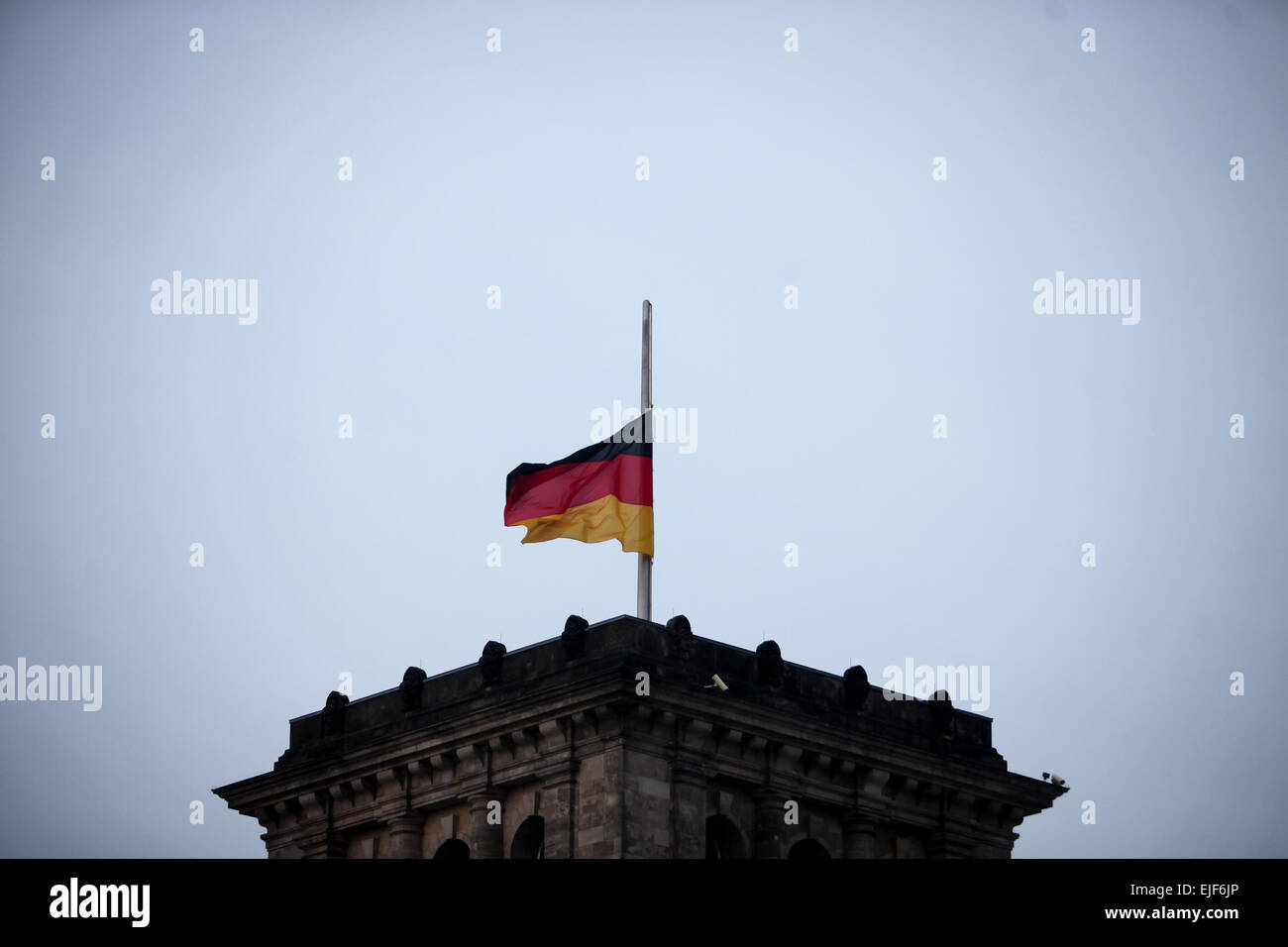 Berlino, Germania. 25 Mar, 2015. Un cittadino tedesco sventola a metà montante su l'Edificio del Reichstag (la Camera Bassa del parlamento) per commemorare le vittime del crash aereo di Germanwings a Berlino, Germania, il 25 marzo 2015. Un Airbus A320 del tedesco della compagnia aerea low-cost Germanwings con 150 persone a bordo si è schiantato il martedì nel sud della Francia. © Zhang ventola/Xinhua/Alamy Live News Foto Stock