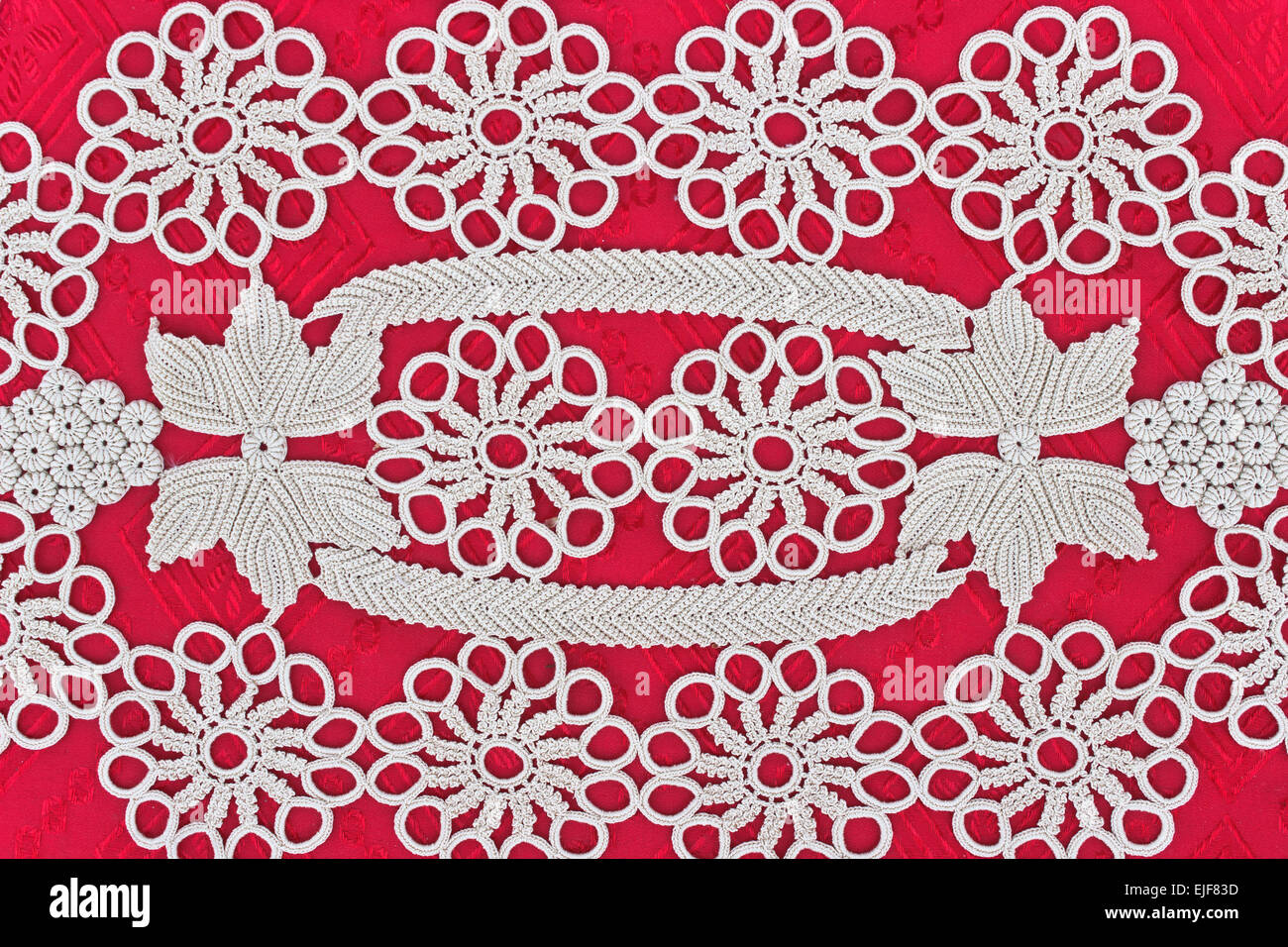 Fatte a mano in pizzo bianco su sfondo rosso Foto Stock