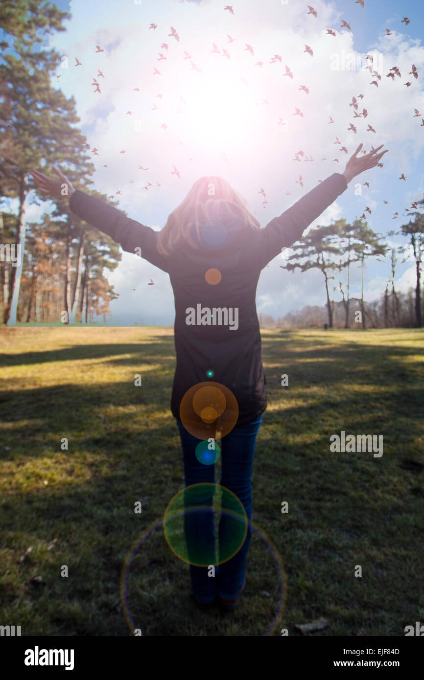 Ragazza giovane diffondendo le mani con gioia e ispirazione rivolta verso il sole,saluto al sole,libertà concetto,bird volare al di sopra del segno freedo Foto Stock