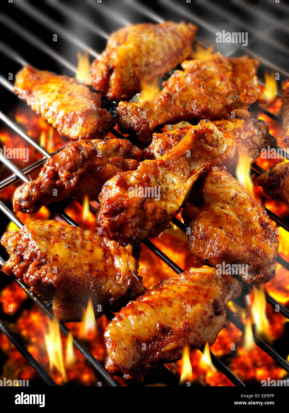 La cottura su un barbecue con carboni ardenti e ALI DI POLLO PICCANTI Foto Stock