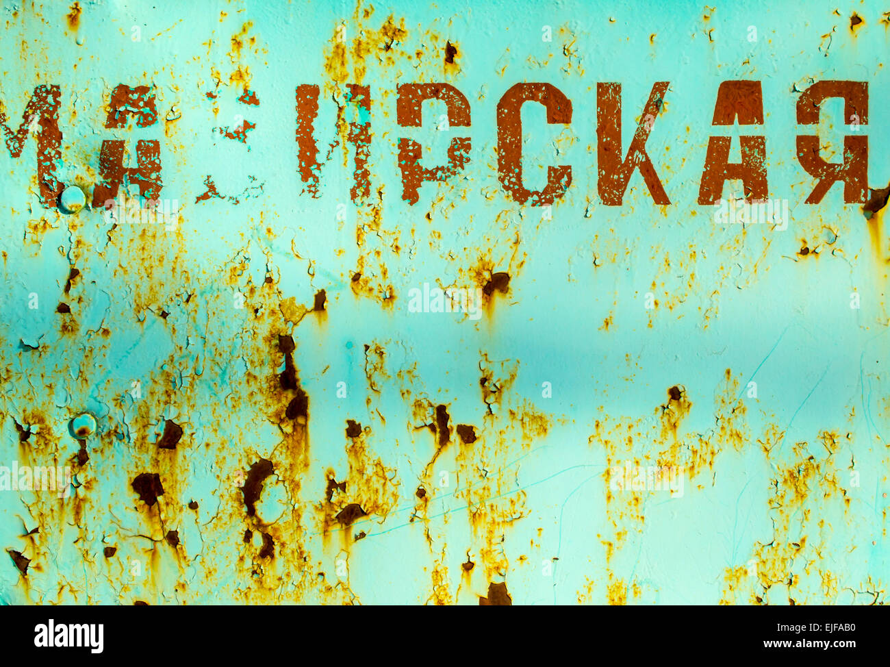 Metallo arrugginito con lettere in russo in rosso scuro Foto Stock