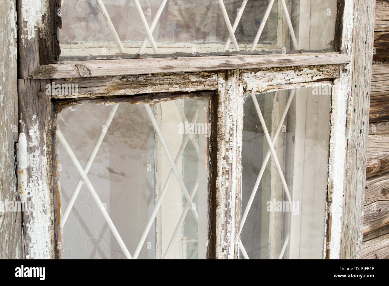 Vecchia finestra bianca telaio con scaglie di vernice dimenticato Foto Stock