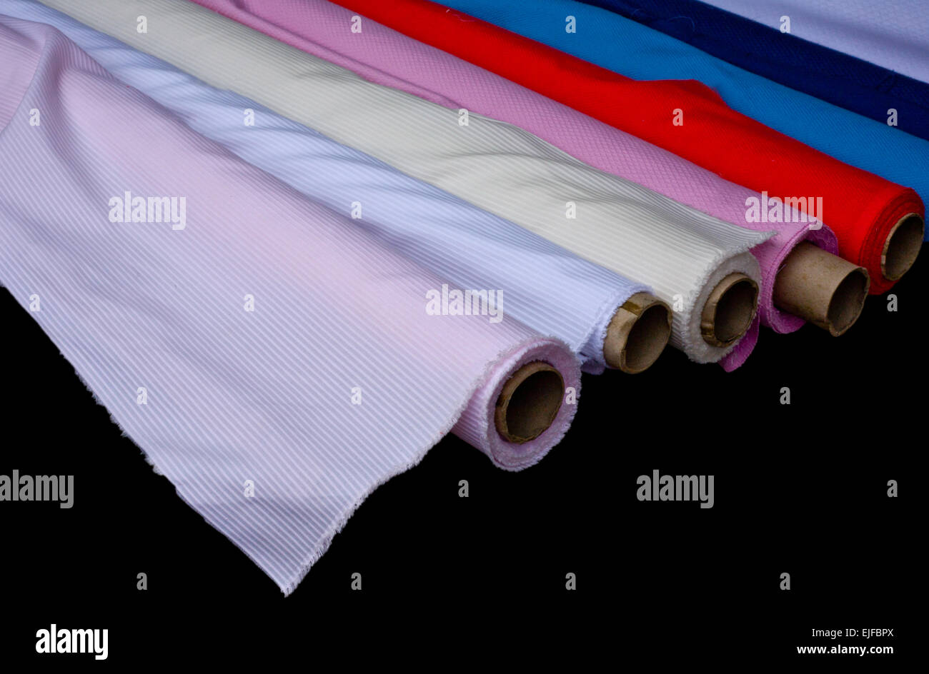 Ruoli multipli di tessuto colorato isolati su sfondo nero Foto Stock