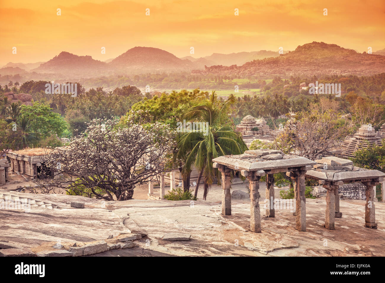 Antiche rovine sulla collina Hemakuta in arancione tramonto Cielo in Hampi, Karnataka, India Foto Stock