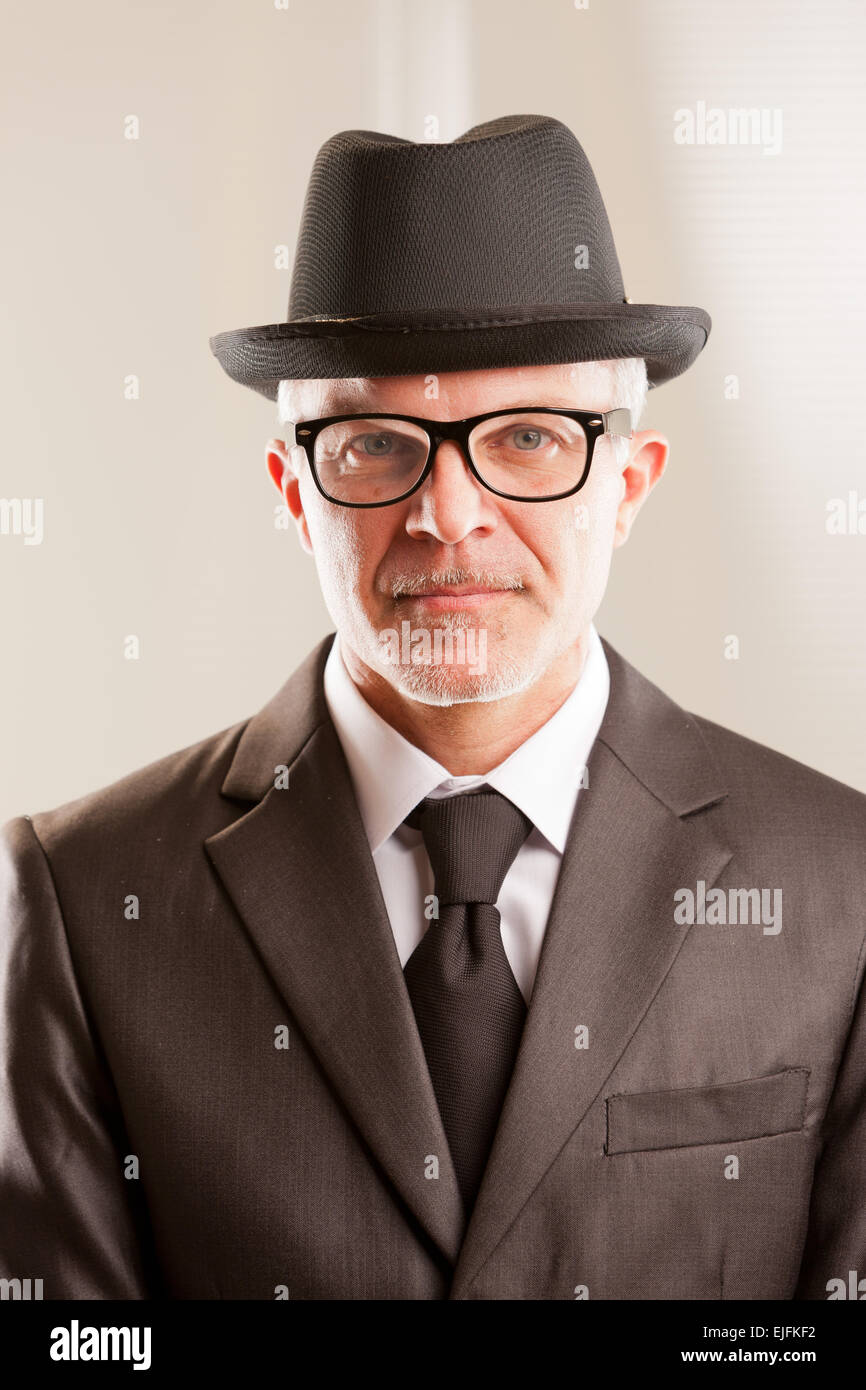 Sorriso furbo uomo con un paio di occhiali e un cappello in stile 1950 Foto Stock