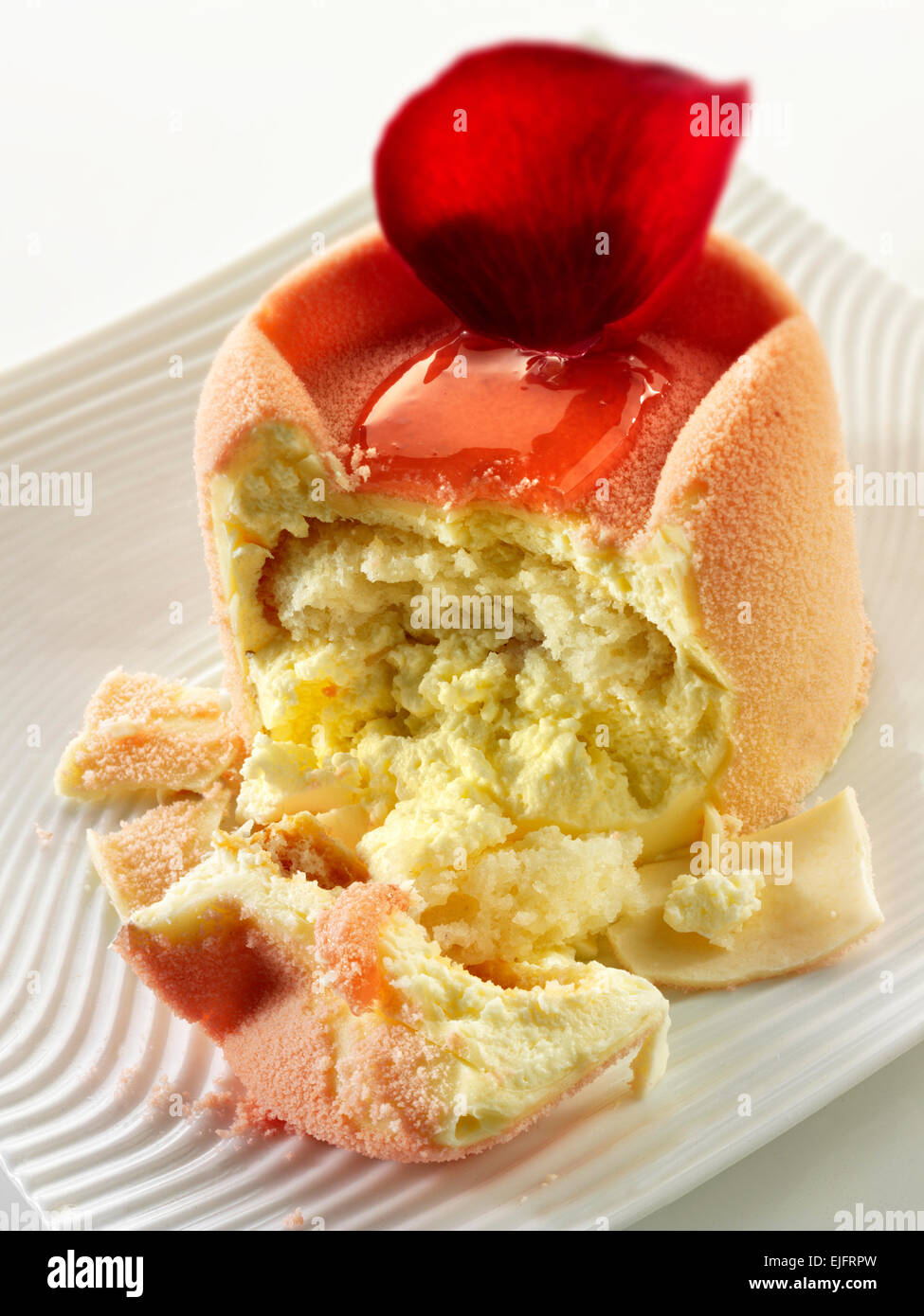 Torta al cioccolato bianco con astuccio in spugna e ripieno di fragole, coperta con polvere di cioccolato bianco rosa e caffè in un tavolo Foto Stock