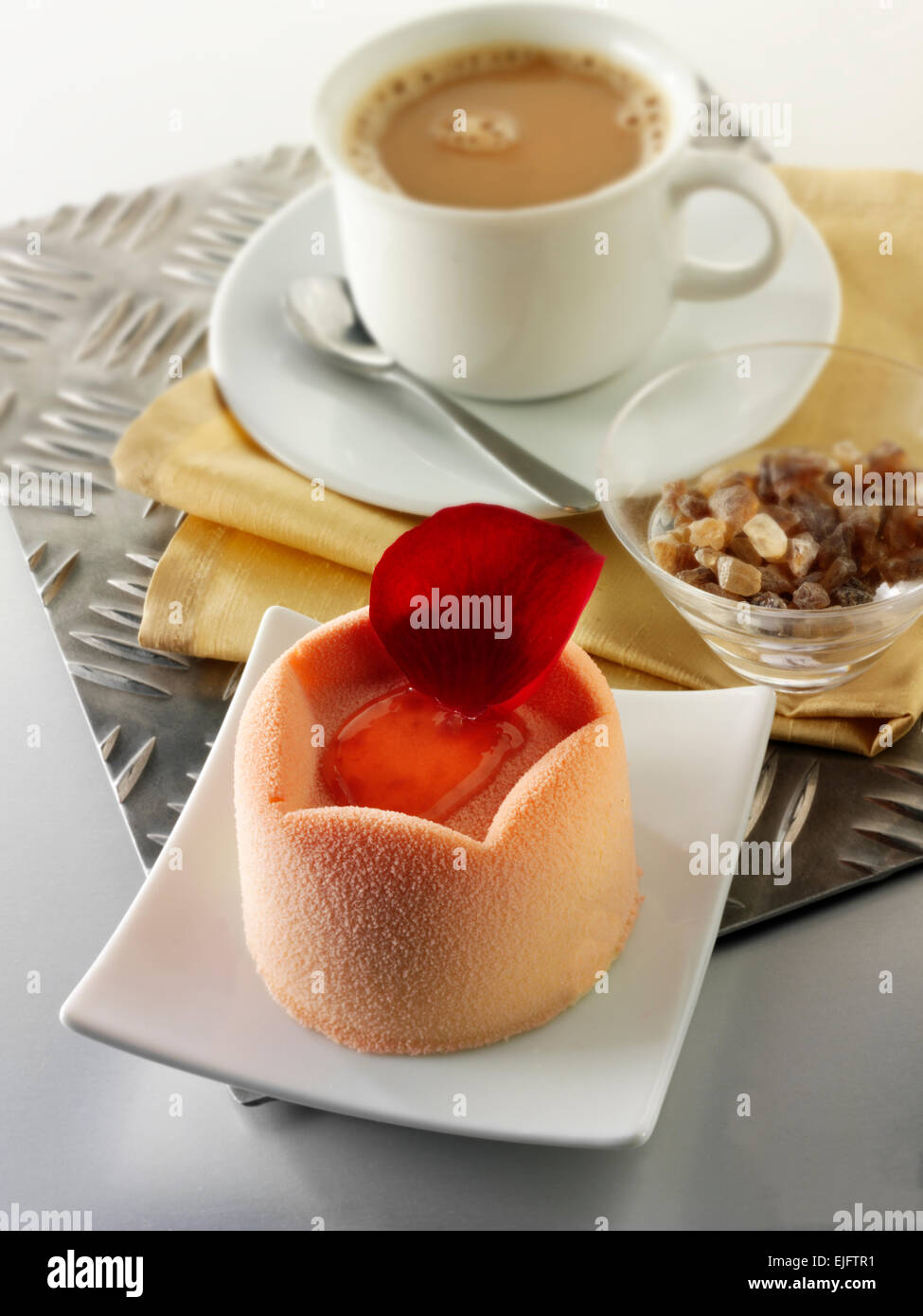 Torta al cioccolato bianco con astuccio in spugna e ripieno di fragole, coperta con polvere di cioccolato bianco rosa e caffè in un tavolo Foto Stock