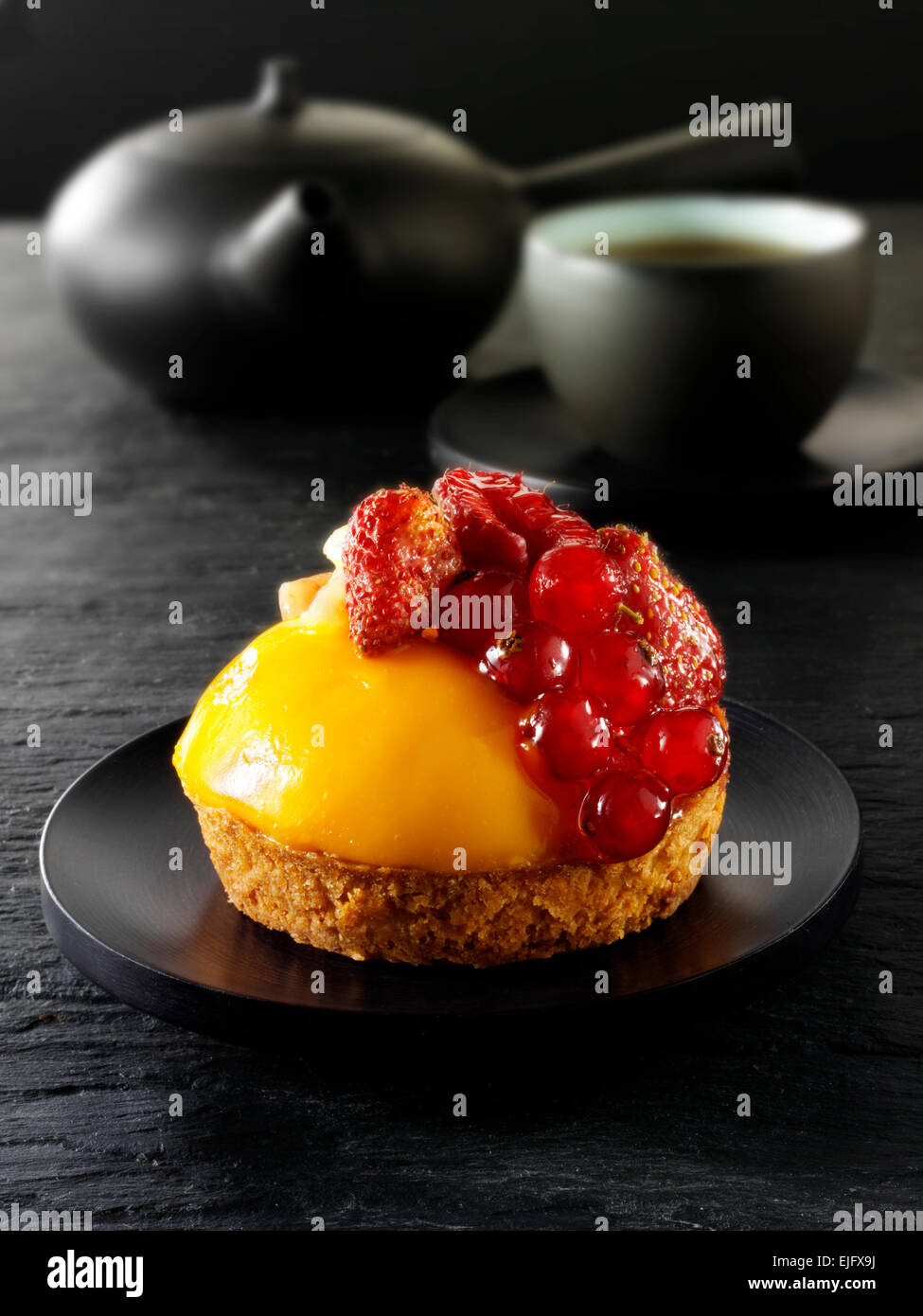 Caffè espresso, con ribes rosso e fragole crema pasticcera tart pasticceria in un cafè con tazza da tè Foto Stock