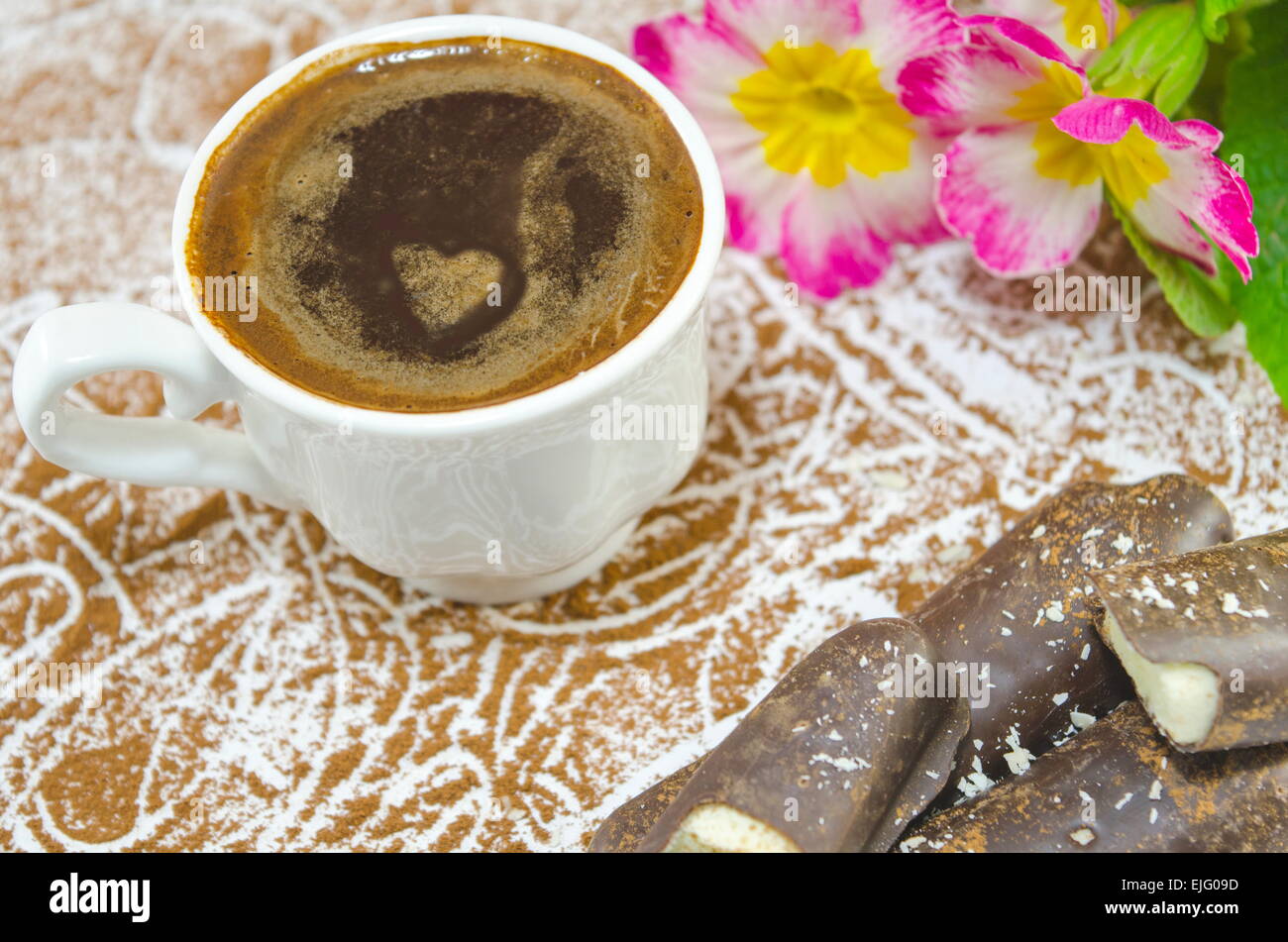 Tazza di caffè con un cuore sottilmente polistirolo sagomato decorato con fiori e a forma di banana cioccolato Foto Stock