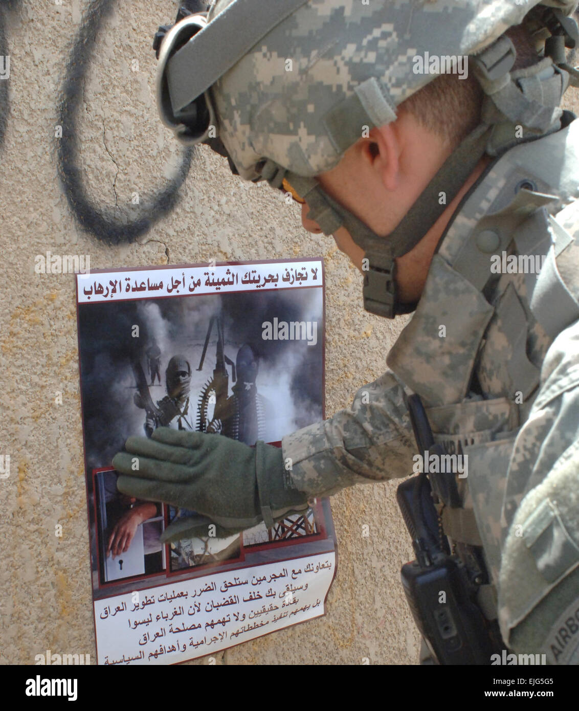 Stati Uniti Il personale dell'esercito Sgt. Don Ingram attribuisce un poster a parete durante una pattuglia nella zona Furat di Baghdad, Iraq, 8 maggio 2007. Il poster contiene la coalizione della forza del messaggio di sicurezza e sollecita la popolazione locale per aiutare a identificare e catturare i ribelli. Ingram è da 318Operazioni psicologiche Company, attaccato al primo battaglione, ventottesimo Reggimento di Fanteria, quarta brigata Team di combattimento, 1° Divisione di fanteria. Il personale Sgt. Bronco Suzuki Foto Stock