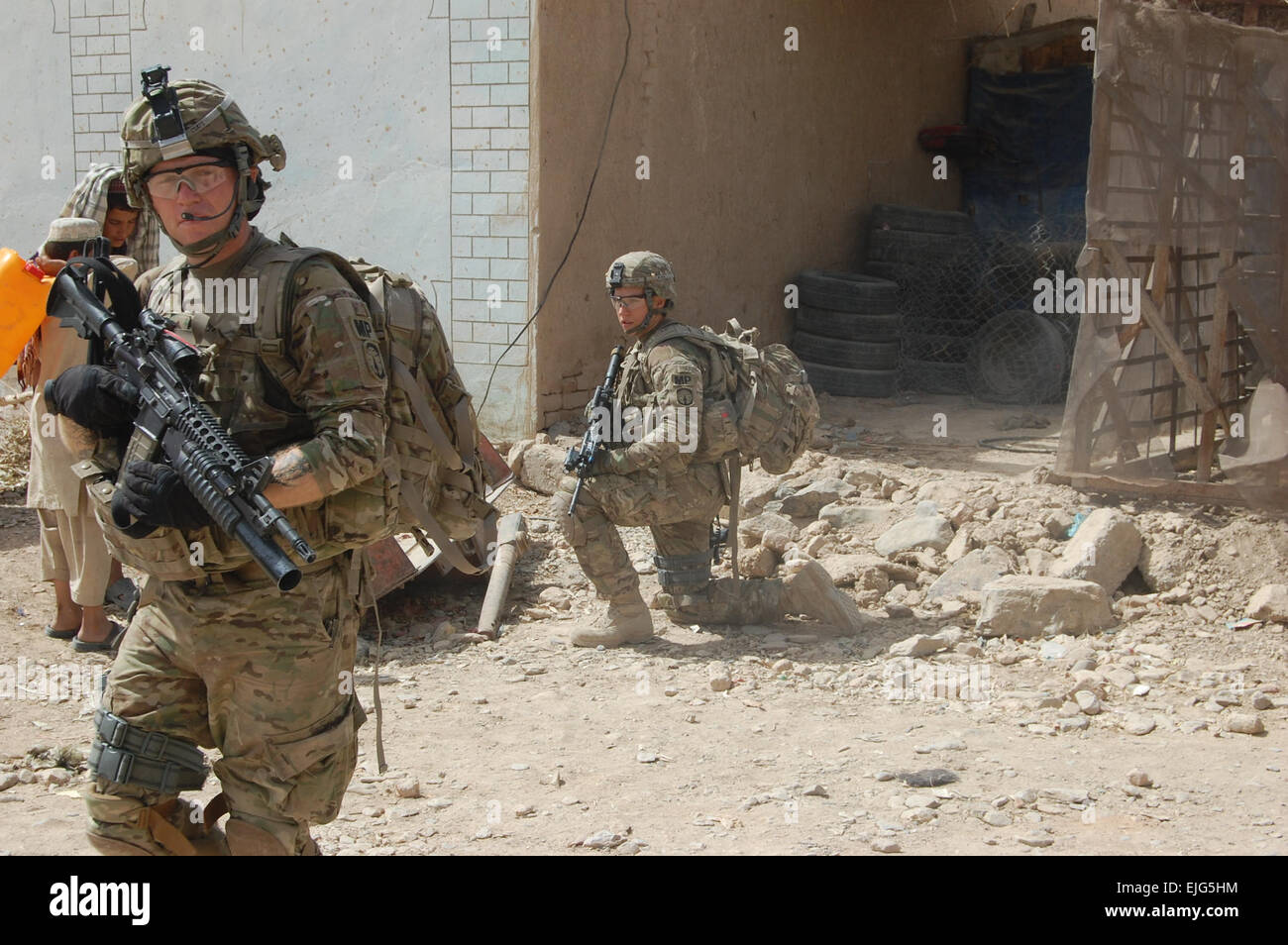 Sgt. Chris cappotti e PFC. William Westmeyer, 561st Polizia Militare Company, attaccato al 2° Brigata Team di combattimento, 4a divisione di fanteria, tirare la sicurezza al di fuori di un mercato all'aperto nel sottodistretto 9 di Kandahar City, 30 luglio. Cappotti' team ha condotto ricerche casuali delle imprese nella zona per identificare possibili esplosivi improvvisati celle del dispositivo. Foto Stock