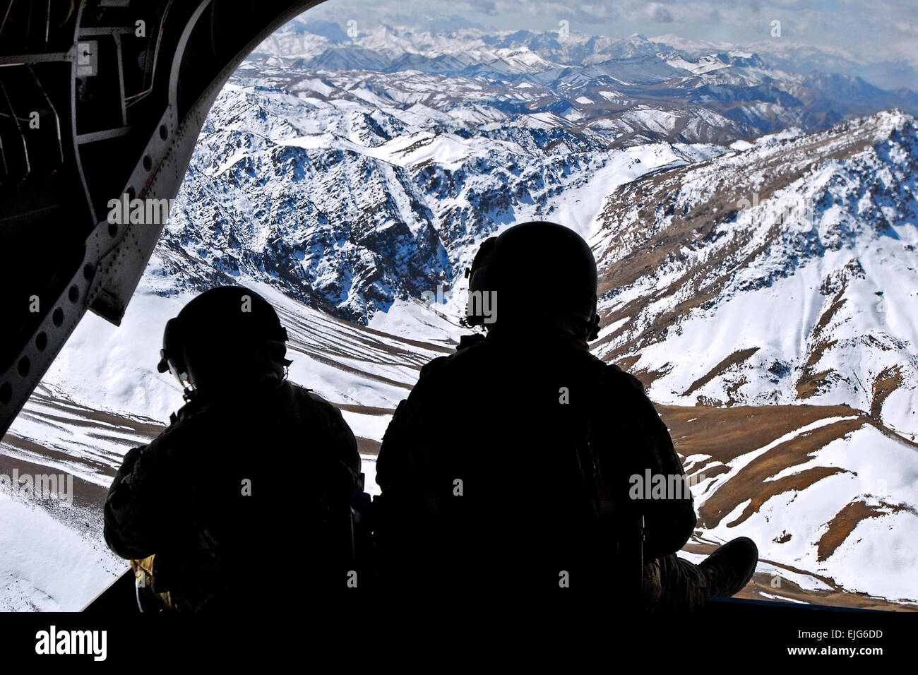 Due membri di equipaggio vegliare sulla rampa posteriore di un CH-47 Chinook mentre volare sopra le montagne in Khas Uruzgan distretto di Afghanistan il 16 marzo 2013. Sgt. Jessi Ann McCormick Foto Stock