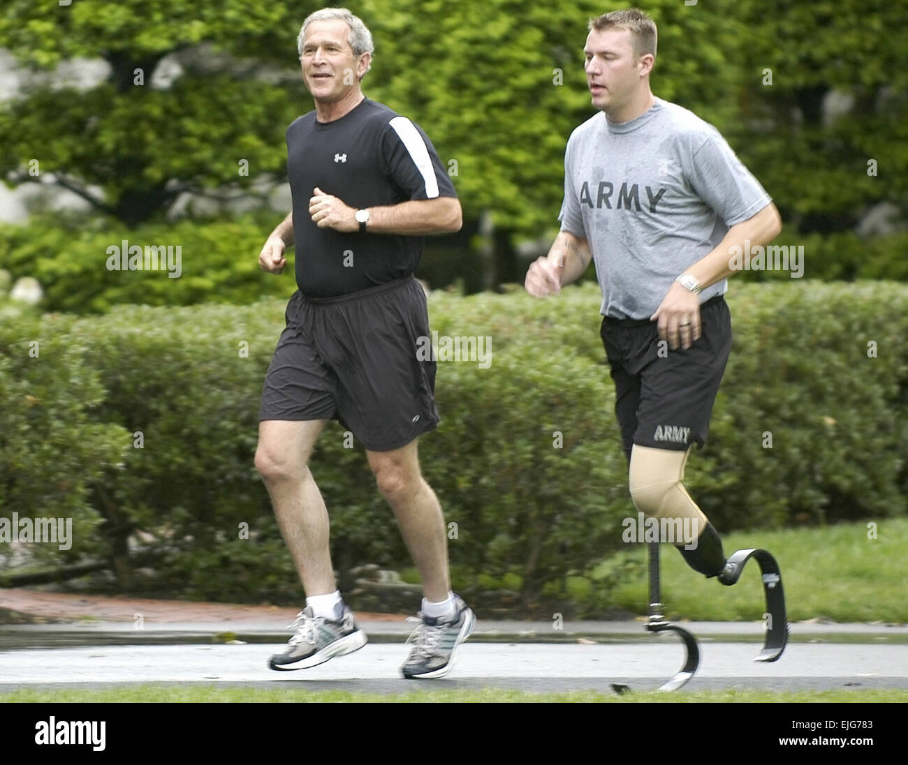 Il personale Sgt. Christian Bagge, che ha perso le gambe in Iraq lo scorso anno quando una bomba sul ciglio della strada ha colpito il suo Humvee, corre con il Presidente Bush il 27 giugno sul prato Sud della Casa Bianca. William D. Moss. . Foto Stock