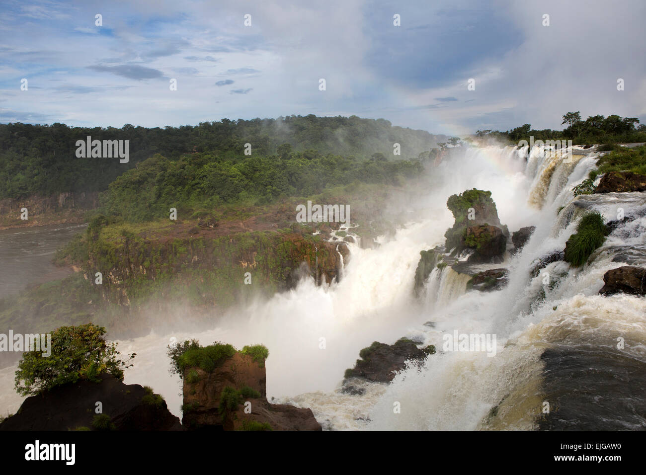 Argentina, Iguazu Falls, Isla San Martin e rainbow su cascate dopo forti piogge Foto Stock