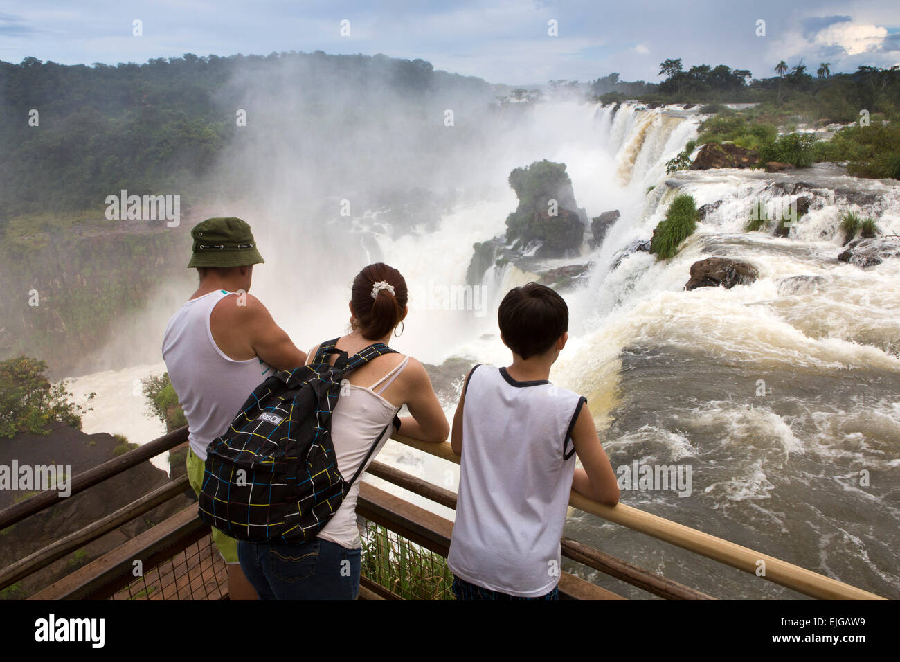 Argentina, Iguazu Falls, turisti godendo di vista di acqua che fluisce oltre le cascate dopo forti piogge Foto Stock
