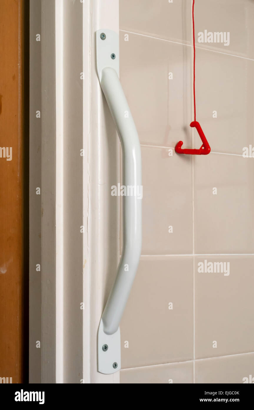 Maniglia e allarme di emergenza tirare la cordicella in bagno adatto per l'uso da parte di una persona anziana o disabile. Foto Stock