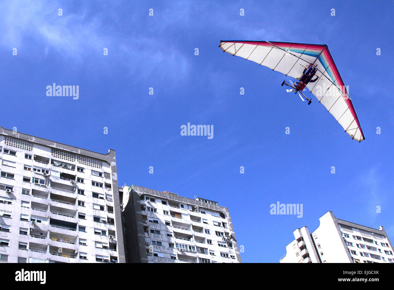I motorizzati deltaplano volare sopra gli edifici residenziali in città Foto Stock