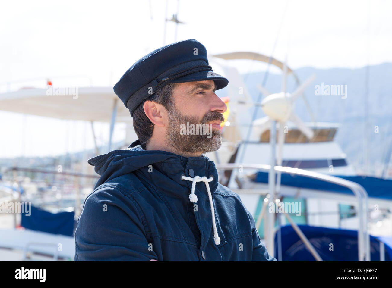 Sailor uomo in marina port con barche di sfondo e capsula di chiusura di colore blu Foto Stock
