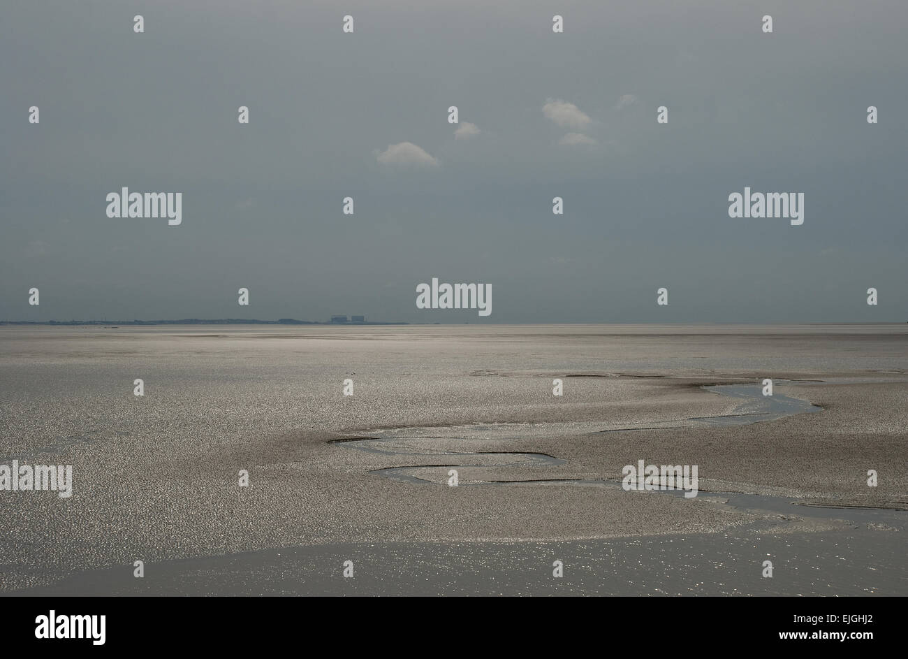 Gioco di luce attraverso la baia di Morecambe da Silverdale in Lancashire che mostra una vasta area sabbiosa e un piccolo gruppo di nuvole che passano nascondono il pericolo in essa Foto Stock