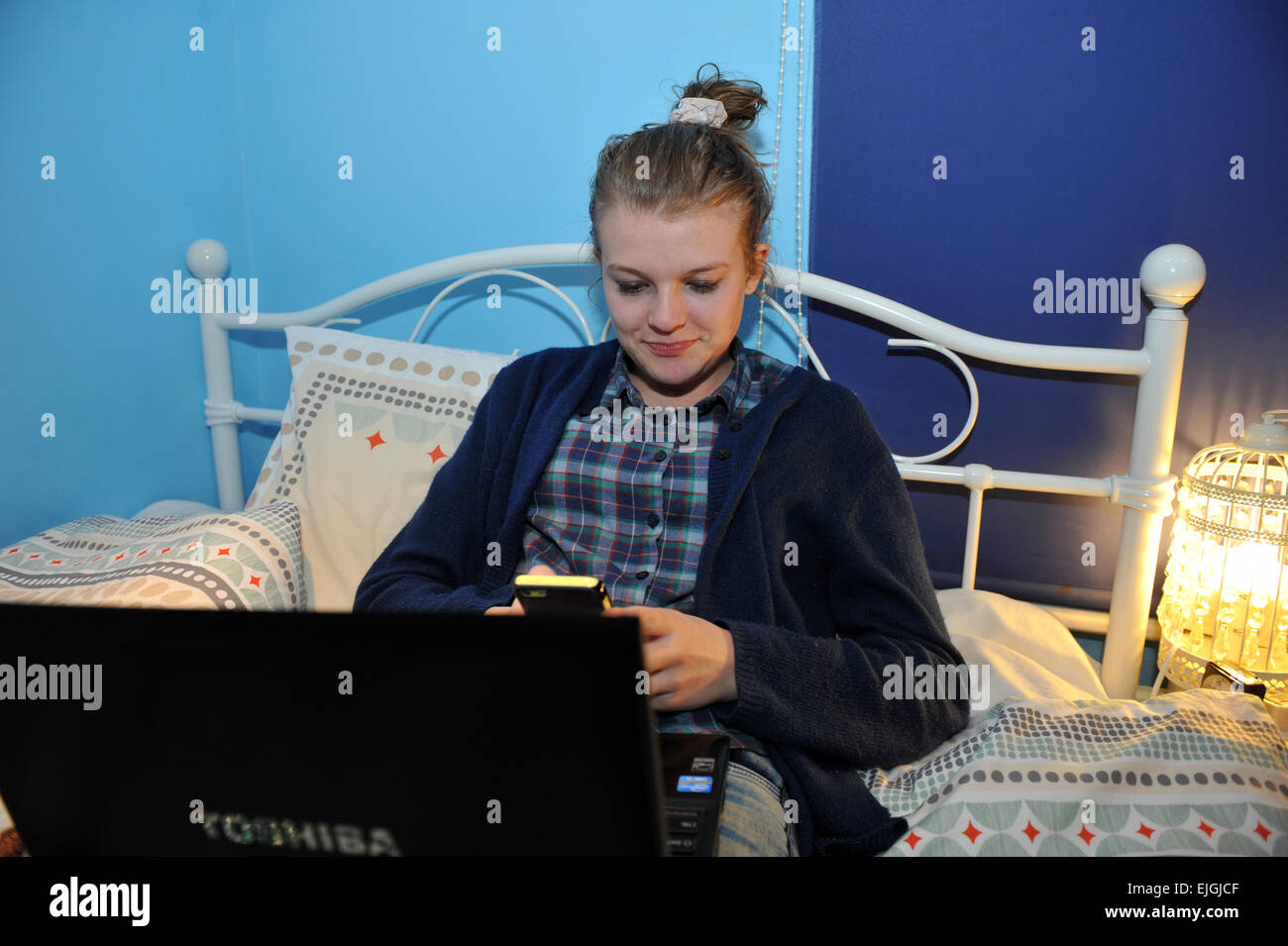 Una ragazza adolescente utilizza il suo computer portatile nella sua camera da letto. Modello rilasciato Foto Stock